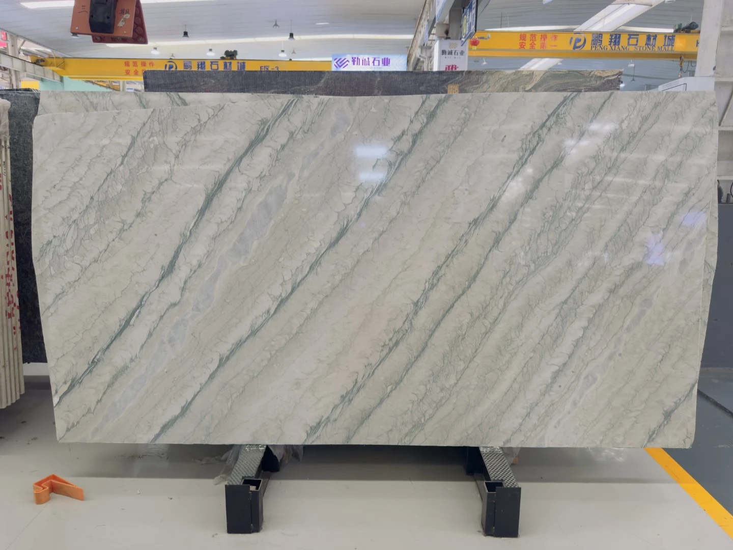 Client-approved Luce Di Luna Quartzite slab with a pale white background and diagonal gray-green natural veining. Client-approved Luce Di Luna Quartzite slab with a pale white background and diagonal gray-green natural veining.